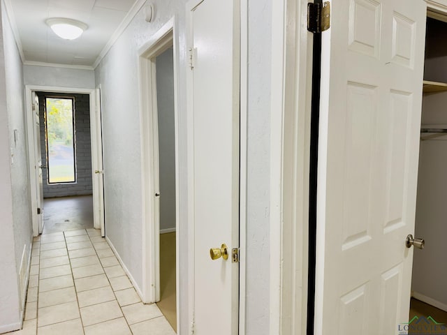 hall with light tile patterned floors and crown molding