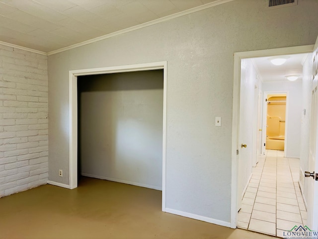 unfurnished bedroom with ornamental molding and brick wall