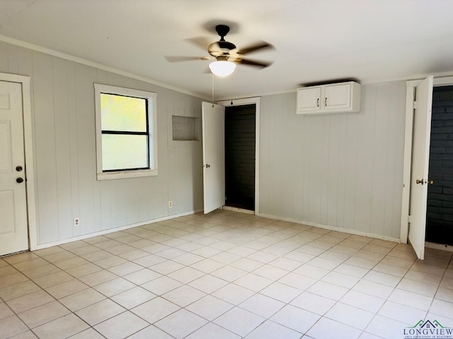 unfurnished bedroom featuring ceiling fan, ornamental molding, and light tile patterned floors