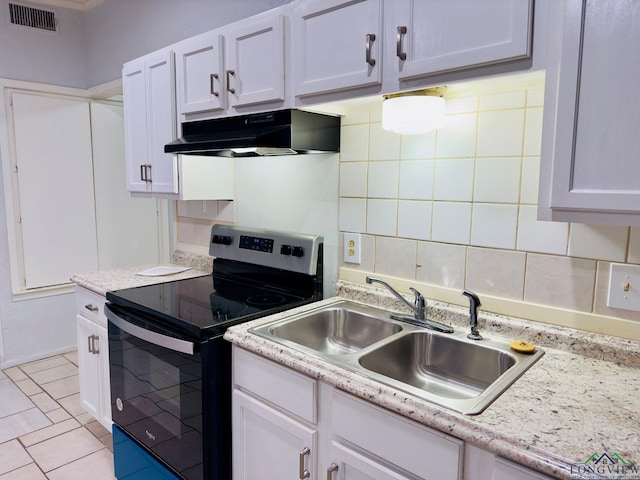 kitchen with electric range, sink, light tile patterned floors, tasteful backsplash, and white cabinets