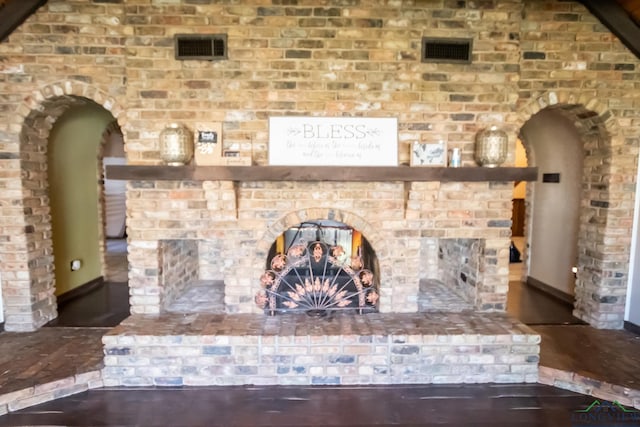 interior details featuring visible vents, arched walkways, baseboards, and wood finished floors