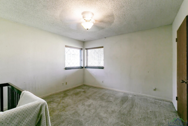 unfurnished bedroom featuring baseboards, carpet, and a textured ceiling