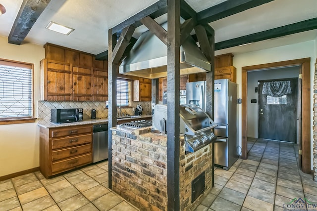 kitchen featuring decorative backsplash, wall chimney exhaust hood, brown cabinetry, and appliances with stainless steel finishes