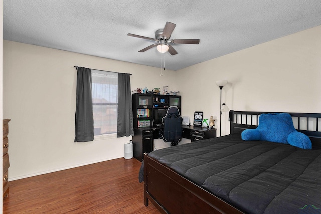 bedroom featuring ceiling fan, dark hardwood / wood-style flooring, and a textured ceiling