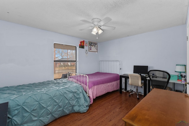 bedroom featuring dark hardwood / wood-style floors, a textured ceiling, and ceiling fan