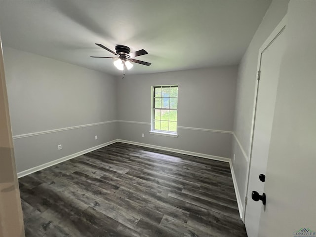 unfurnished room featuring dark wood-style floors, ceiling fan, and baseboards