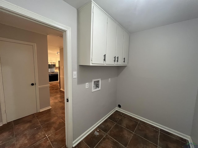 laundry room featuring dark tile patterned flooring, hookup for a washing machine, cabinet space, and baseboards