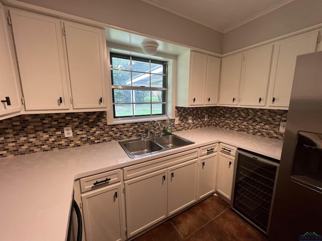 kitchen featuring beverage cooler, a sink, light countertops, tasteful backsplash, and stainless steel fridge