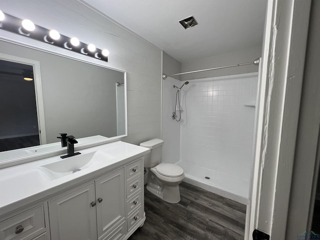 full bathroom featuring vanity, walk in shower, wood finished floors, and toilet