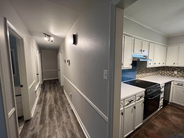 hall featuring ornamental molding, dark wood-style flooring, and baseboards