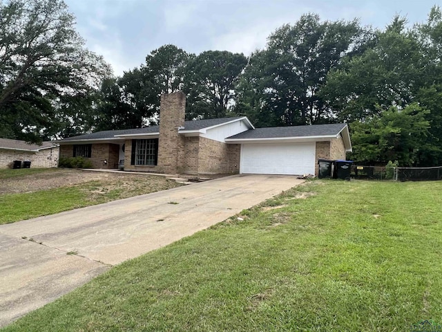 view of front of property with an attached garage, fence, driveway, a front lawn, and a chimney