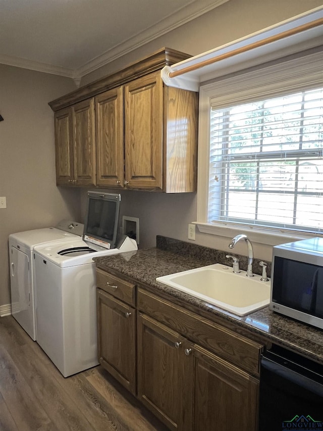 laundry room with ornamental molding, independent washer and dryer, sink, and dark wood-type flooring