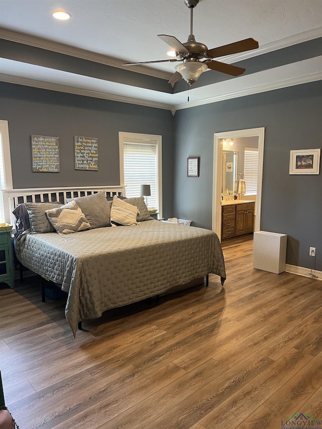 bedroom with ceiling fan, ensuite bathroom, wood-type flooring, and crown molding