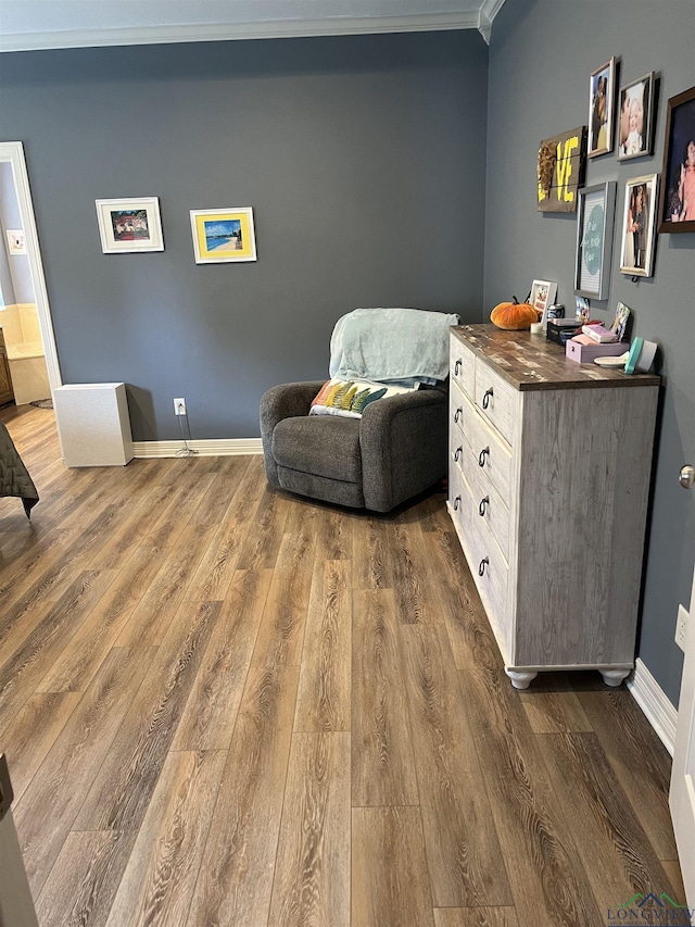 sitting room featuring dark wood-type flooring and ornamental molding