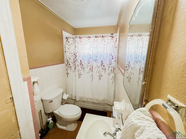 full bath with a sink, toilet, wainscoting, tile walls, and curtained shower
