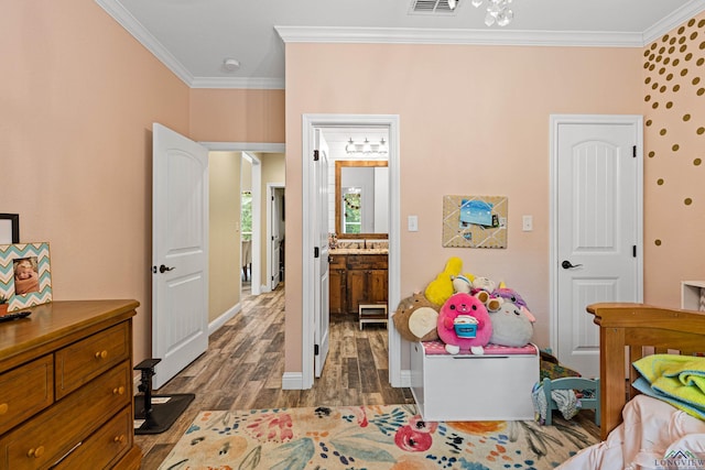 bedroom with ensuite bathroom, crown molding, and dark wood-type flooring