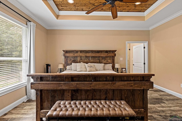 bedroom with hardwood / wood-style floors, a raised ceiling, ceiling fan, and crown molding