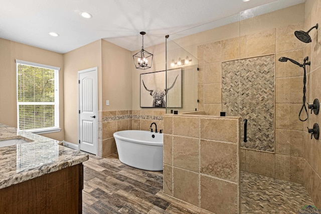 bathroom with vanity, wood-type flooring, tile walls, independent shower and bath, and a chandelier