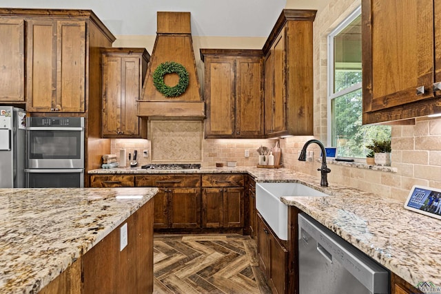 kitchen with sink, stainless steel appliances, tasteful backsplash, dark parquet floors, and premium range hood