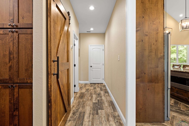 corridor featuring hardwood / wood-style floors and a barn door