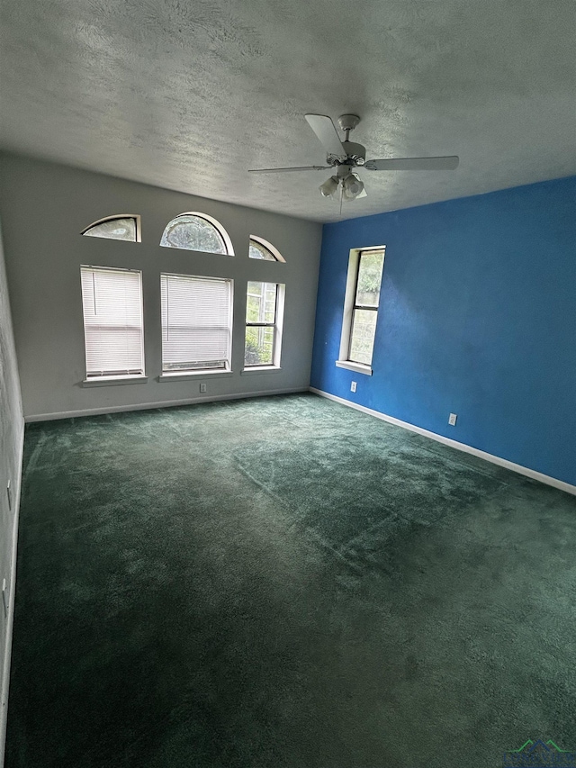 carpeted empty room featuring a ceiling fan, a textured ceiling, and baseboards
