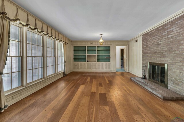 15 Covington Dr, Longview, TX 75602 - unfurnished living room featuring ornamental molding, hardwood / wood-style flooring, and a fireplace