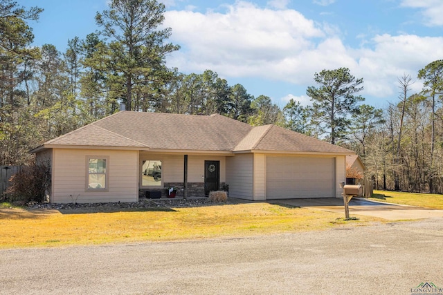 single story home with a garage, a shingled roof, concrete driveway, and a front yard