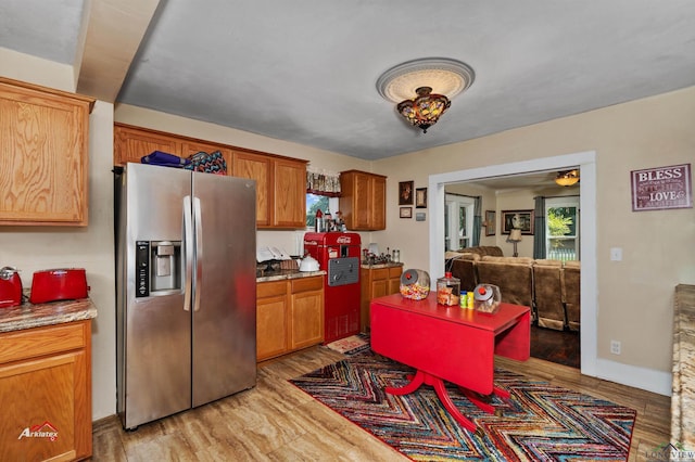 kitchen with stainless steel fridge with ice dispenser, plenty of natural light, ceiling fan, and light hardwood / wood-style flooring