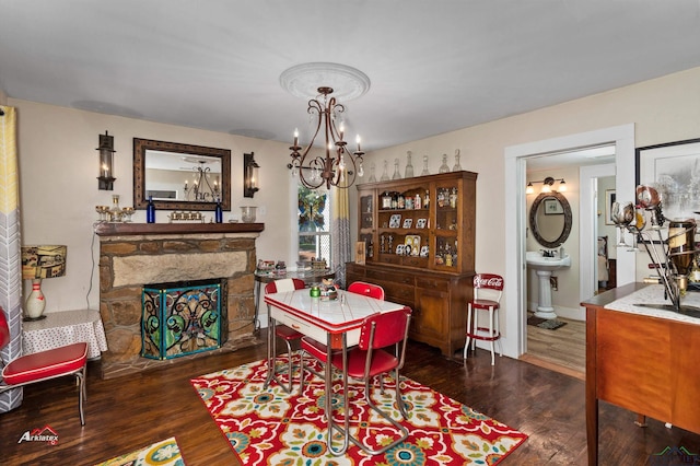 dining space with a fireplace, dark wood-type flooring, and a notable chandelier