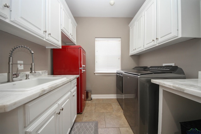 washroom with cabinets, separate washer and dryer, sink, and light tile patterned floors