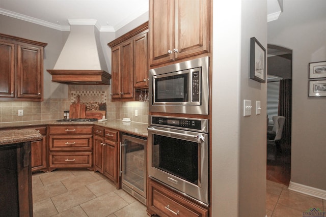 kitchen with premium range hood, ornamental molding, stainless steel appliances, light stone countertops, and decorative backsplash