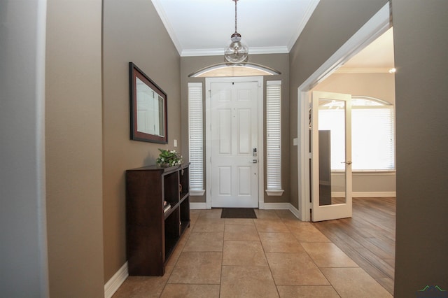 tiled foyer entrance featuring crown molding