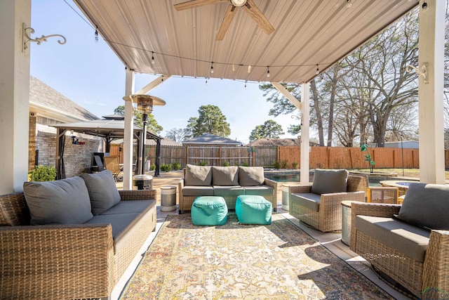 view of patio / terrace with ceiling fan, a gazebo, outdoor lounge area, and a fenced backyard