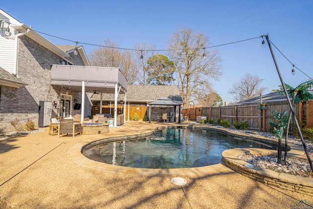 view of pool featuring a patio, a fenced backyard, a fire pit, a gazebo, and a fenced in pool