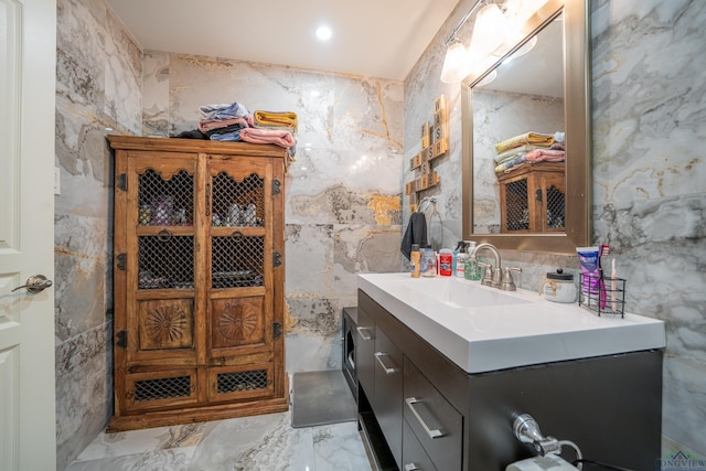 interior space with marble finish floor, a sink, and tile walls