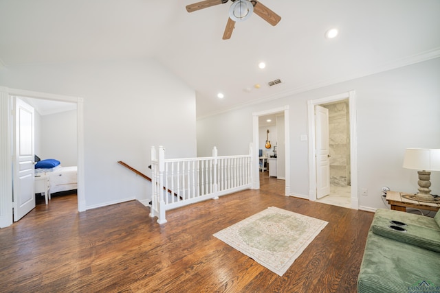 spare room featuring lofted ceiling, wood finished floors, visible vents, and crown molding