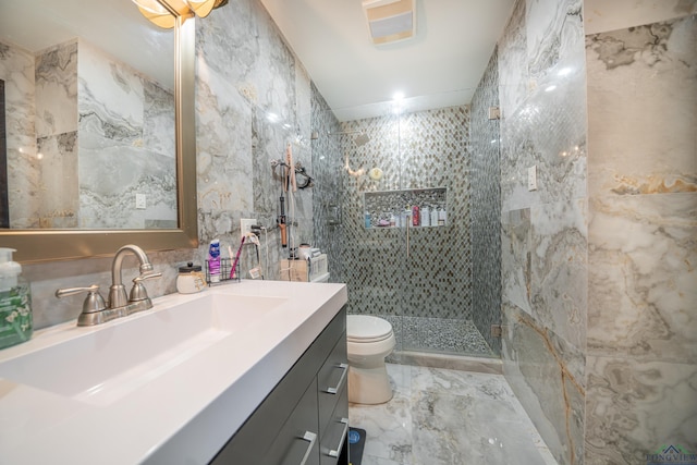 full bathroom featuring marble finish floor, tile walls, toilet, a tile shower, and vanity