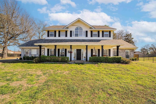 view of front facade featuring covered porch, a front yard, and fence