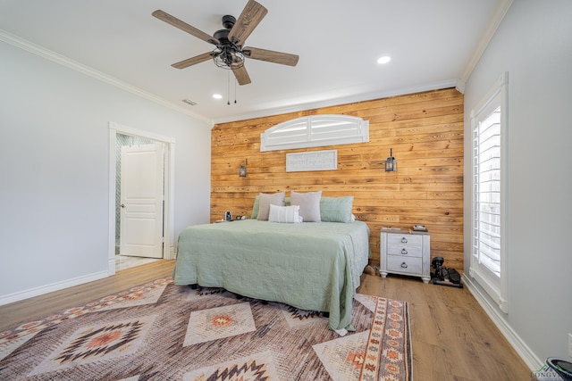 bedroom featuring baseboards, visible vents, crown molding, and wood finished floors