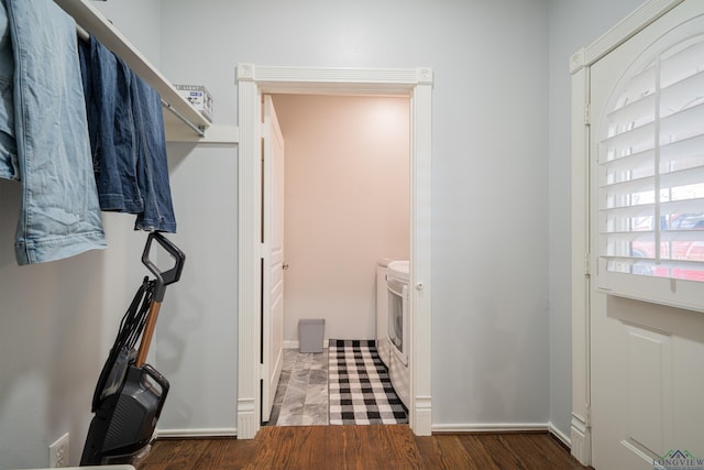 interior space with laundry area, washing machine and clothes dryer, and wood finished floors