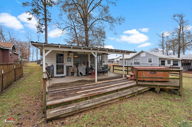 rear view of house featuring a yard, a hot tub, and a deck