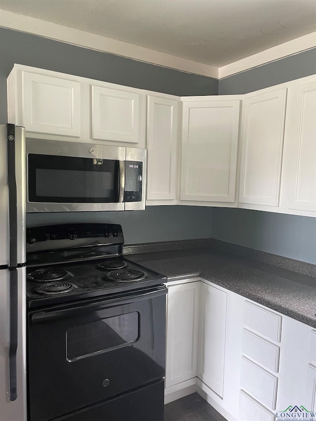 kitchen featuring dark countertops, white cabinetry, and stainless steel appliances