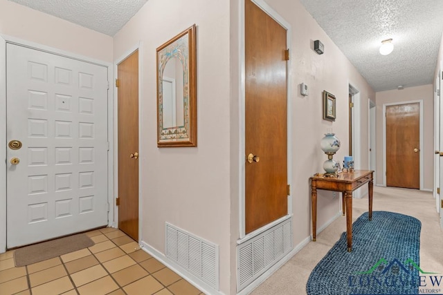 tiled foyer with a textured ceiling