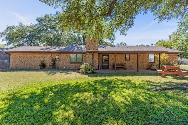 rear view of house with a lawn and a patio