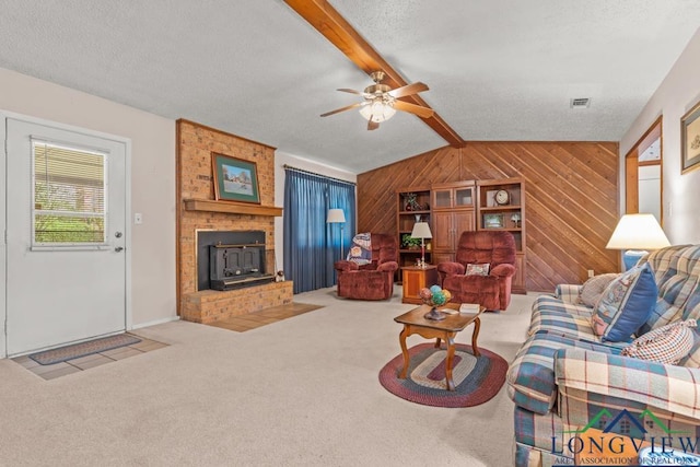 living room with wood walls, light carpet, lofted ceiling with beams, ceiling fan, and a textured ceiling