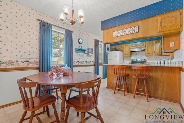 dining space featuring sink and a chandelier