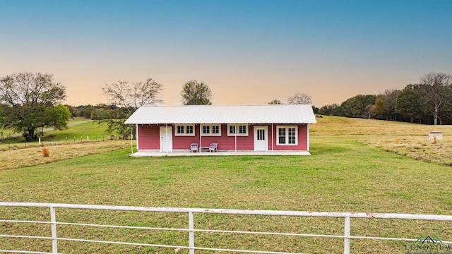 view of front of house featuring fence private yard, metal roof, and a front yard