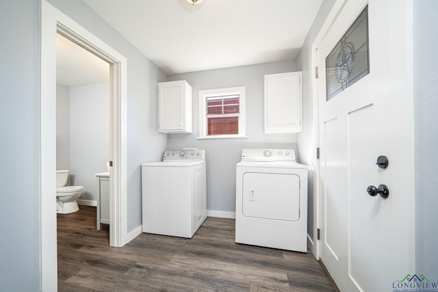 clothes washing area with dark wood-style flooring, cabinet space, independent washer and dryer, and baseboards