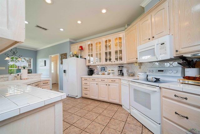 kitchen featuring crown molding, white appliances, tile countertops, decorative backsplash, and visible vents