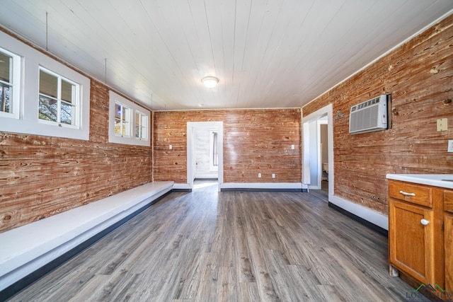 interior space with wooden walls, dark wood-style floors, wooden ceiling, and a wall mounted air conditioner
